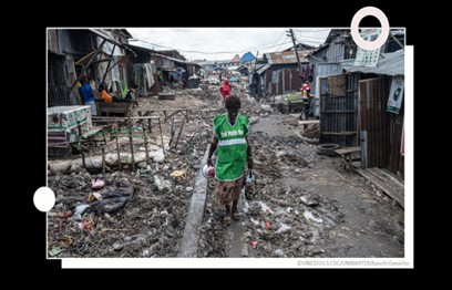 A CHW walks through the streets of Nigeria with a megaphone during polio campaigns